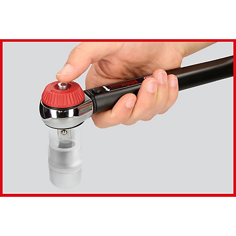 Hand hält einen Drehmomentschlüssel. Der Knopf ist rot, der Rest schwarz und silber.